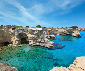 Picturesque seascape with cliffs, rocky arch and stacks (faraglioni), at Torre Sant Andrea, Salento...