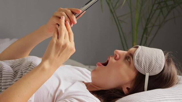 Shocked beautiful Caucasian girl reading news online via modern gadget connected to wireless internet sees something awful saying oh no having unhappy facial expression.