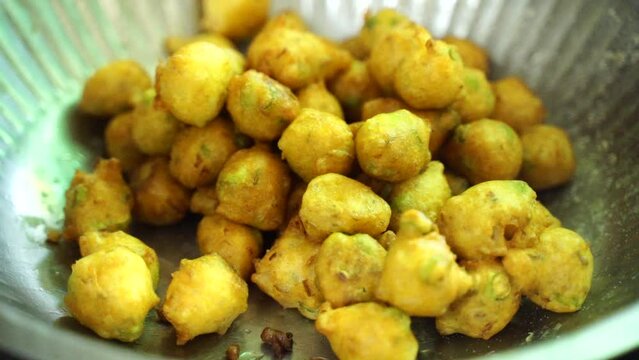 Fried pakoras are stored in a pot after frying