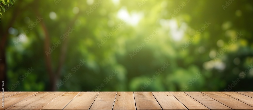 Poster green tree garden with wood table for food display bokeh light background in spring and summer