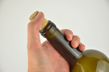 One dark green (olive) wine bottle neck (lip) with cork in a hand mockup on a white background,...