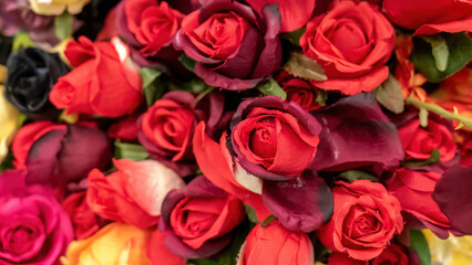 Lots of fake flowers artificial red roses fake plants made of fabric at the store, faking reality and nature simple abstract concept, shallow dof, decorative elements, nobody. Imitation of real plants