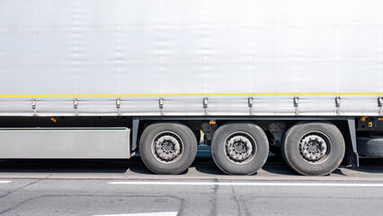 Generic simple commercial transport truck trailer side view detail, wheels closeup plain background with copy space Logistics company goods transportation business economy finance concept, backdrop