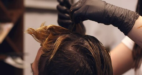 Professional hairdresser coloring man hair. Process of a guy color hair at hairdresser. Hair coloring man. Professional hairdresser dying hair.