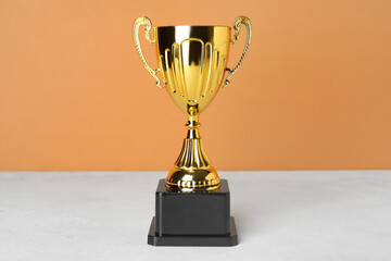 Gold cup on table near orange wall