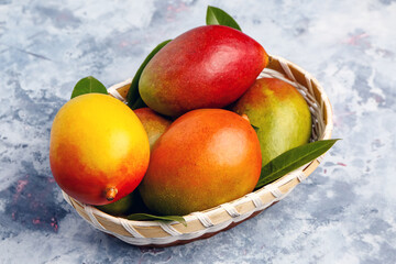 Basket of fresh ripe mangoes on grunge background