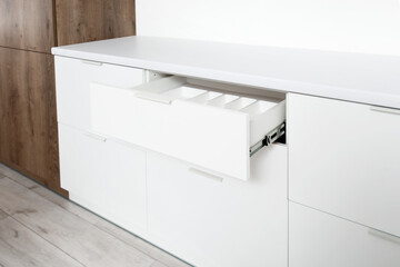 Open white drawer in light kitchen