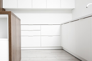 Interior of light kitchen with white drawers and sink