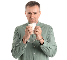 Mature junkie in handcuffs with drugs on white background