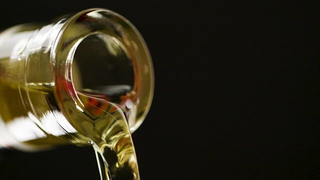 Close Up Of Liquor Pouring Out Of The Mouth Of A Bottle Of Alcohol. 