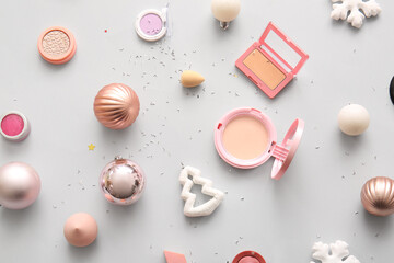 Composition with makeup products and Christmas decor on grey background