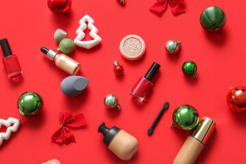 Composition with decorative cosmetics and Christmas decor on red background