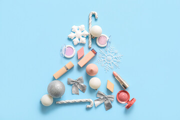 Christmas tree made of makeup products and decor on blue background