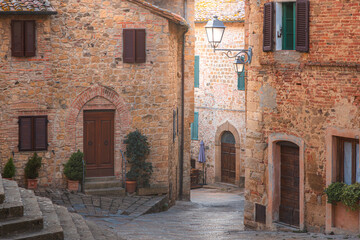 Fototapeta na wymiar Charming and quaint narrow old town backstreet in in the historic Tuscan village of Monticchiello, Tuscany.