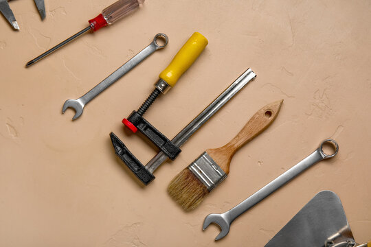 Set of construction tools on beige background