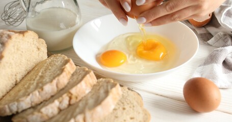Female hands break eggs into a plate. Slices of bread on a cutting board. Cooking food. A series of photos of Bread with Egg Recipe.