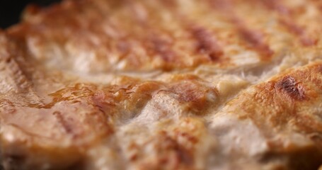 Pieces of Delicious juicy meat are fried on a grill pan with steam and bubbles of fat. Cooking steaks. Preparing food in the kitchen. Close-up dolly shot.