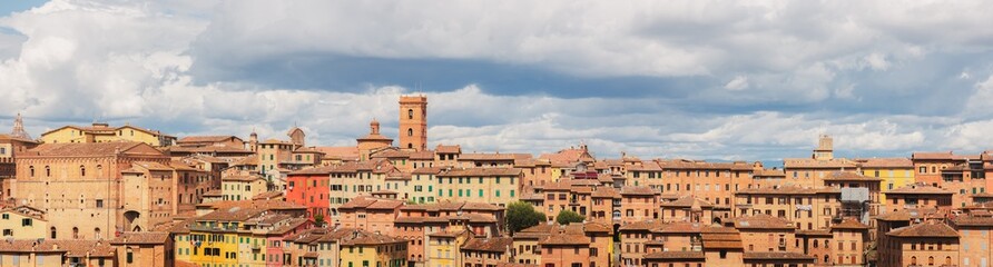 Wide panoramic view of colourful and scenic townscape of historic hilltop village Siena, Tuscany, Italy.