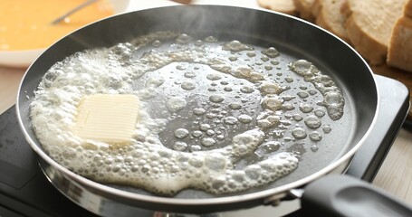 Butter in a hot frying pan. Bubbles and steam of melted butter. Cooking food. A series of photos of...