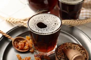 Fotobehang Glass of tasty kvass, raisins and wheat grains on table © Pixel-Shot