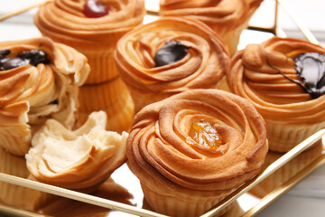 Tray of tasty cruffins with chocolate and jam on table