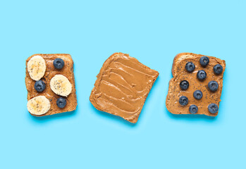 Toasts with peanut butter, blueberries and banana on blue background