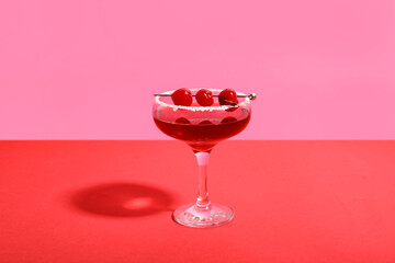 Glass of Cosmopolitan cocktail with cherries on colorful background - obrazy, fototapety, plakaty
