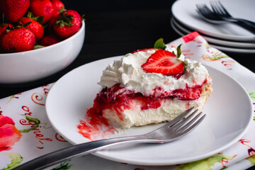 Slice of Strawberry Cream Pie with Whipped Cream: Piece of strawberry pie on a small plate with a bite taken out