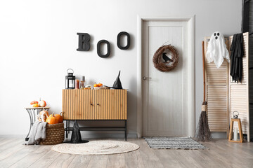 Interior of festive hallway with wooden cabinet, door and Halloween decorations
