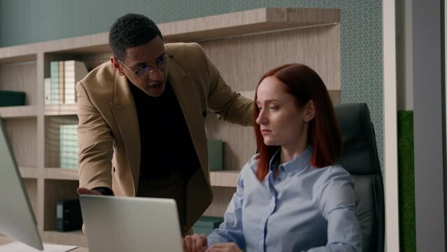 Angry boss African American man shout on woman lazy sloth worker dissatisfied with computer problem business mistake quarrel abuse conflict multiracial businessman and businesswoman arguing in office