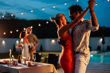 Couple dancing during poolside party