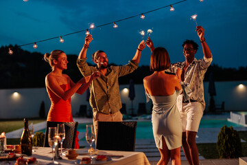 Friends dancing during evening pool party