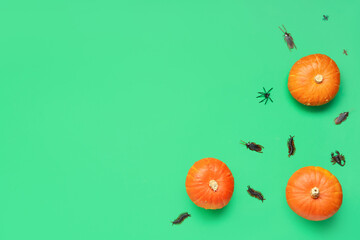 Halloween composition with pumpkins and candy bugs on green background