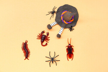 Halloween composition with candy bugs and witch doll on beige background