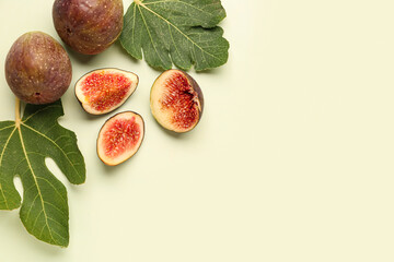 Fresh ripe figs and leaves on green background