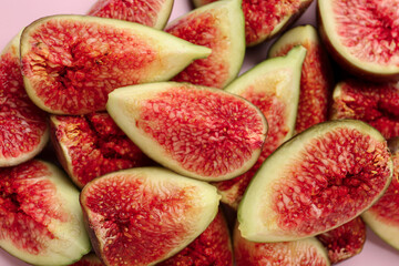 Pieces of fresh ripe figs on pink background, closeup