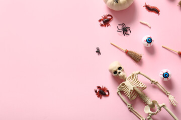 Halloween composition with candy bugs, skeleton and brooms on pink background