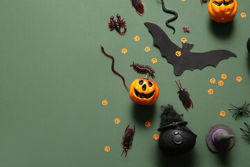 Halloween composition with candy bugs and pumpkins on green background