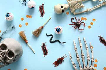 Halloween composition with candy bugs, skeletons and eyeballs on blue background