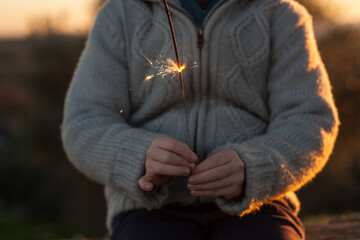 child, hands, holding, new year, sparkler, sunny, winter, day, sunset., close up, faceless,...