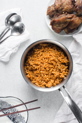 Jollof rice in a silver saucepan, homemade nigerian jollof rice in a pot, overhead view of authentic homemade west african jollof rice