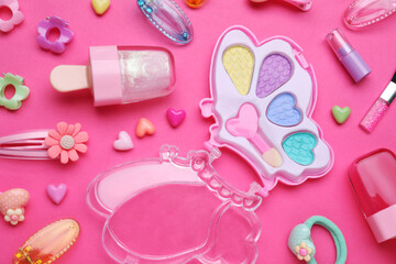 Children's kit of makeup products and accessories on pink background, flat lay