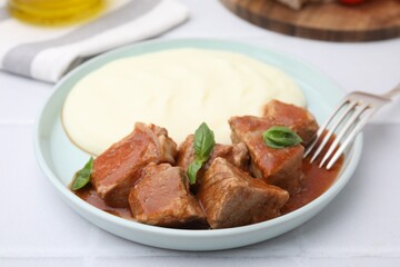 Delicious goulash served with mashed potato on white table, closeup