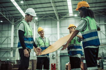 The tech prepare cardboard sheet with precision before automating production in the paper factory.