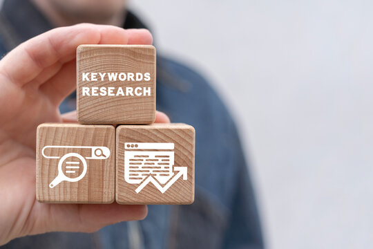 Man holding wooden cubes sees inscription: KEYWORDS RESEARCH. Keyword Research and SEO optimization concept. Keyword planner.