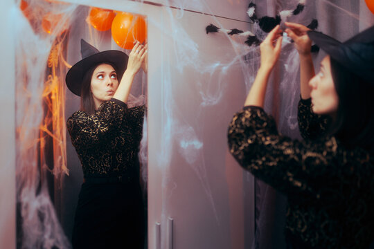 Woman Decorating the Home for Halloween Funny. girl arranging fake spiderweb for carnival costume party
