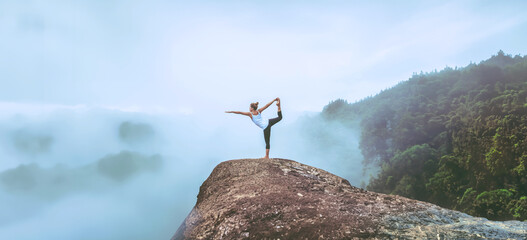 Asian women relax in the holiday. Travel relax.  Play if yoga. On the Moutain rock cliff. Nature of...