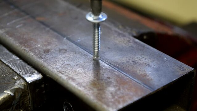 Tornillo autoperforante introduci&eacute;ndose en un perfil met&aacute;lico. 