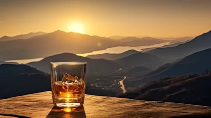 Foto op Plexiglas A whiskey glass and a bottle on a bar table In the background are mountains and a sea of mist at sunset. © somchai20162516