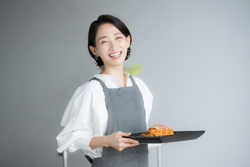 Image of a woman working in a café or a housewife carrying a meal Image of the hospitality...
